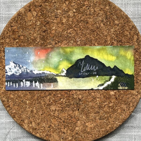 The back of a bookmark printed with Nikki's "Aurora Australis 1" painting. Nikki's signature is written within one of the mountains.