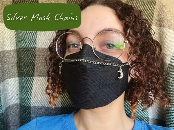 Nikki wearing a silver mask chain on a black N95 mask. There is a rectangle in the top left corner with black text that reads "Silver Mask Chains"