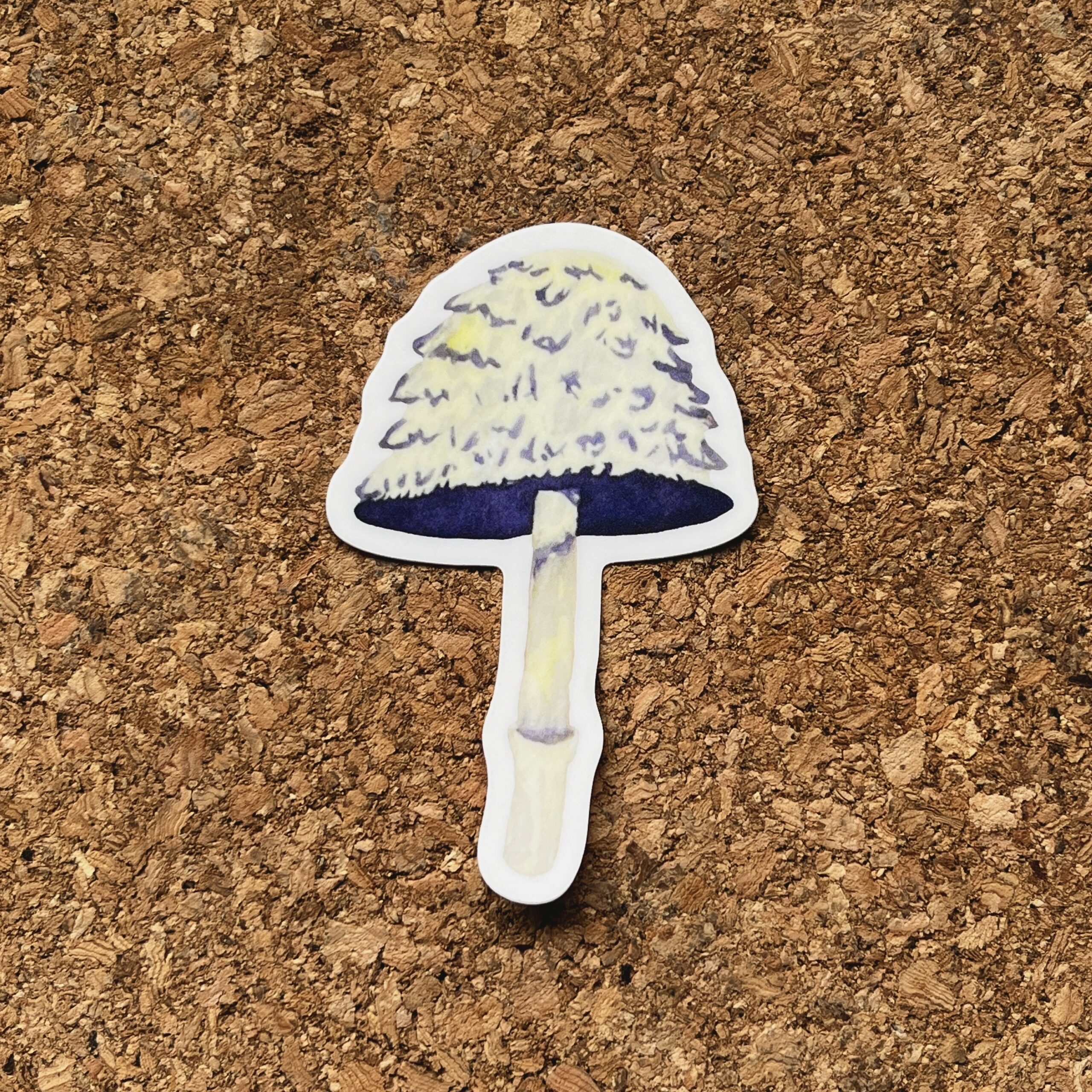 Nikki's "Autumnal Equinox Mushroom" sticker displayed on a cork background.