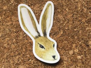 Nikki's "Vernal Equinox Hare" sticker displayed on a cork background.