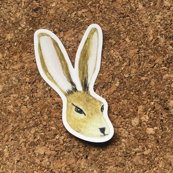Nikki's "Vernal Equinox Hare" sticker displayed on a cork background.