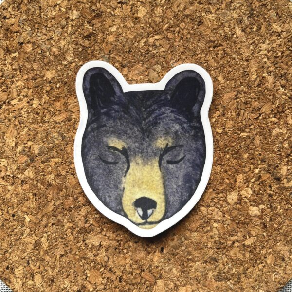Nikki's "Winter Solstice Bear" sticker displayed on a cork background.