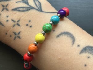 A close up of Nikki's Pride bracelet, worn on her right arm.