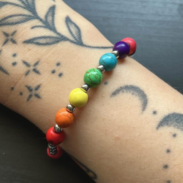 A close up of Nikki's Pride bracelet, worn on her right arm.
